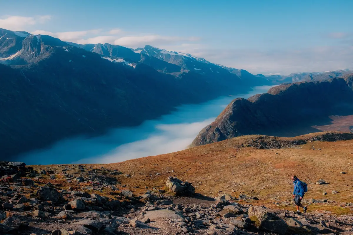 A hiker above a fog-filled valley at Besseggen